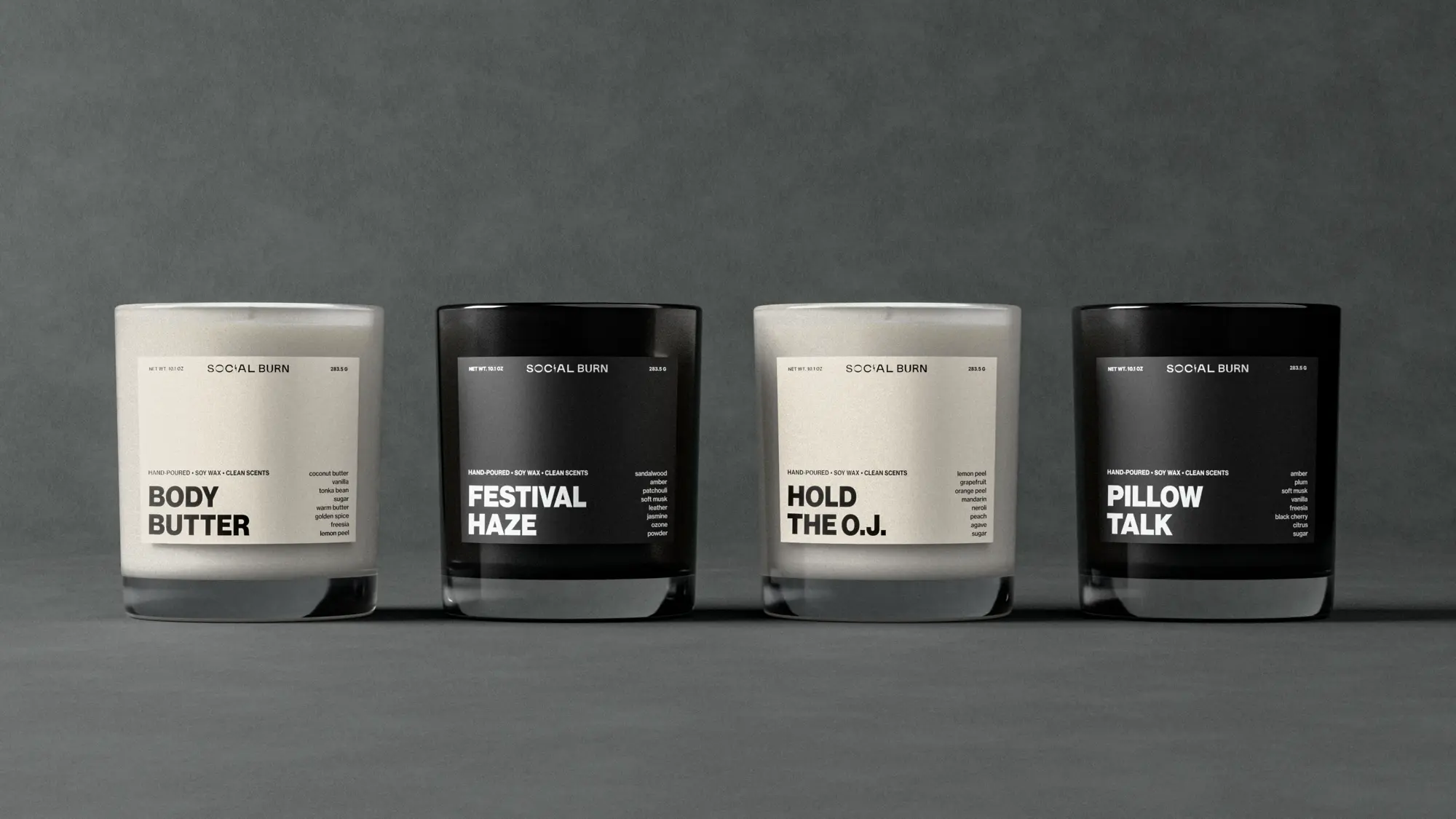 Four candles in a row on a grey backdrop