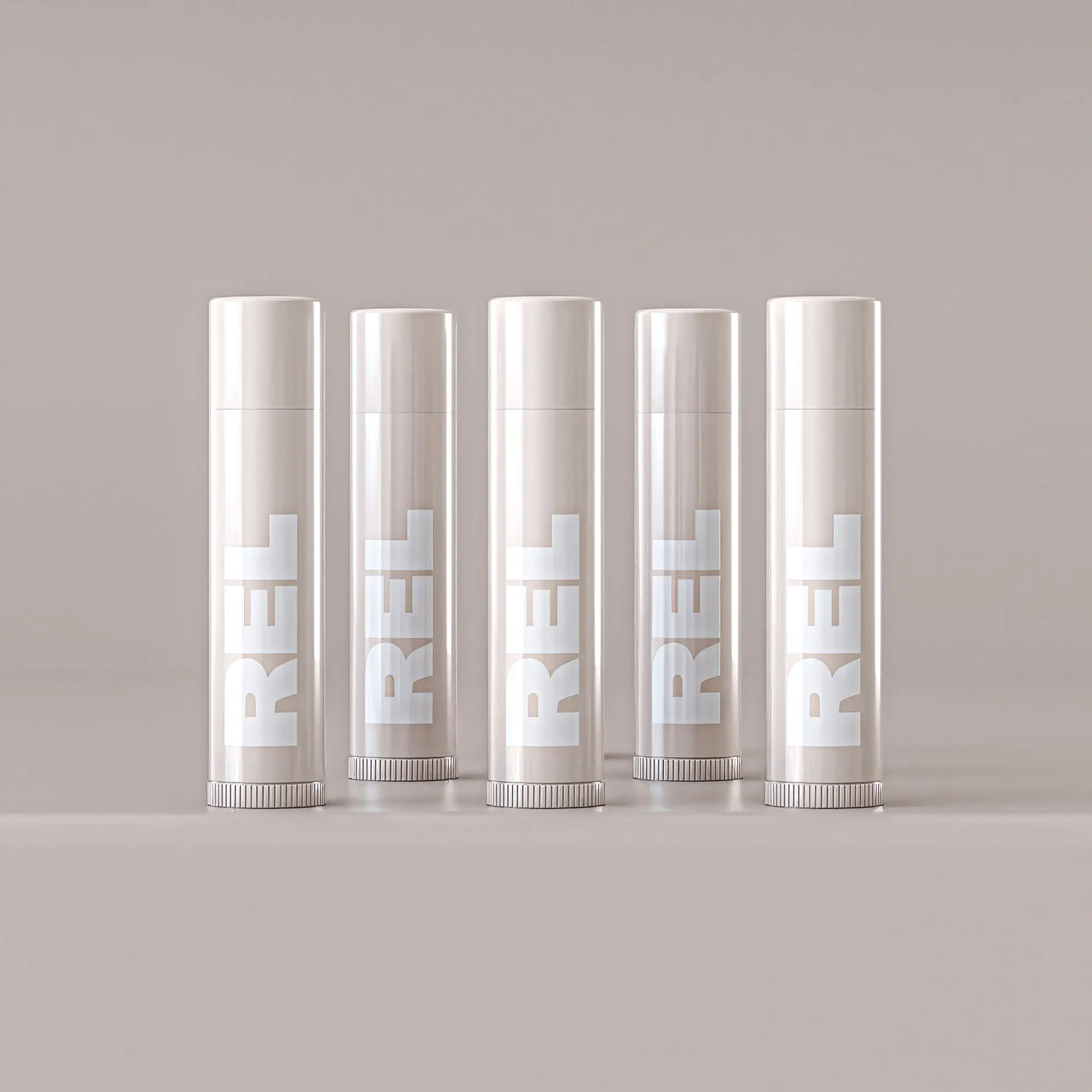 Five lip balm tubes standing in a row against a muted backdrop